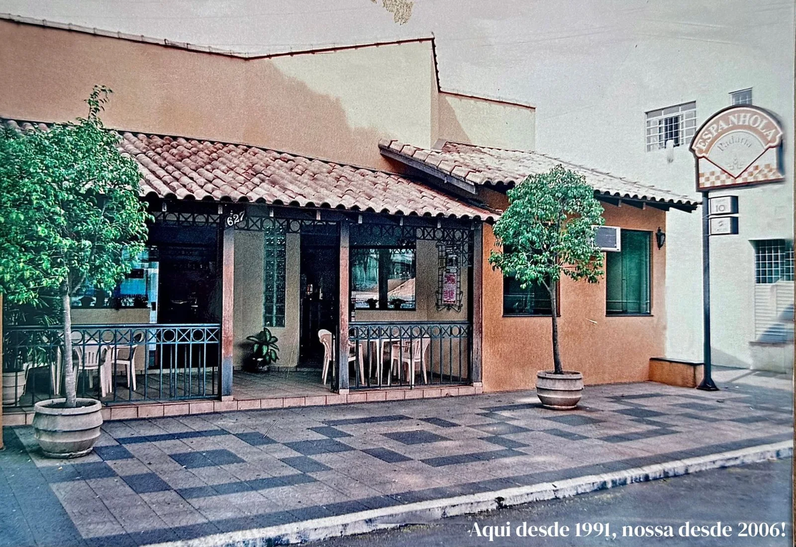 Fachada antiga da Padaria Espanhola na Rua Pernambuco, com as mesas na calçada e a placa da casa