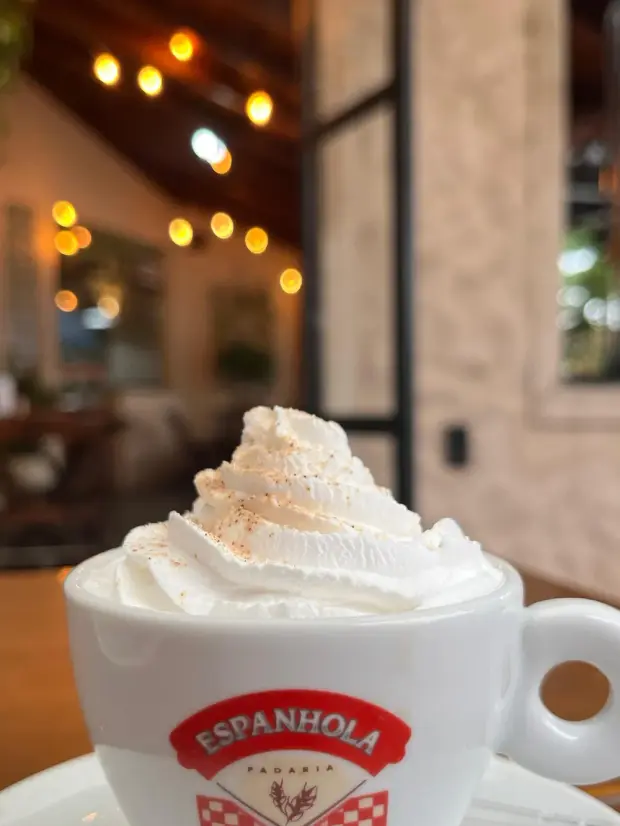 Cappuccino com chantilly e canela na xícara da Padaria Espanhola
