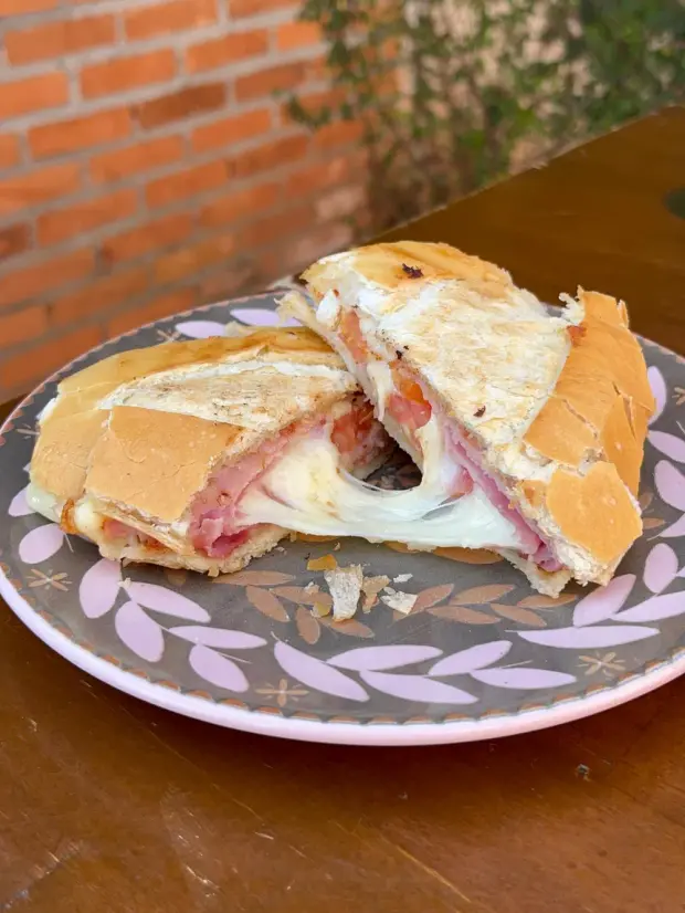 Misto quente na chapa, com o queijo escorrendo entre as duas metades