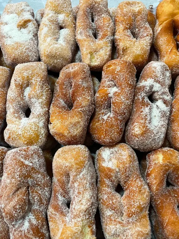 Bandeja cheia de rosquinhas fritas passadas no açúcar